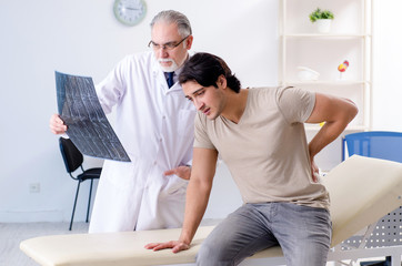 Young man visiting old male doctor radiologist