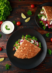 Doner kebab, fried lamb meat with vegetables and garlic sauce in turkish bread