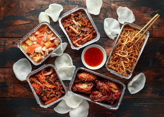 Chinese takeaway food. Crispy shredded beef, sweet and sour chicken wings, egg noodles with bean...
