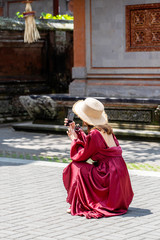 A girl in a straw hat photographed on the phone architecture in the city of Ubud, island Bali, Indonesia