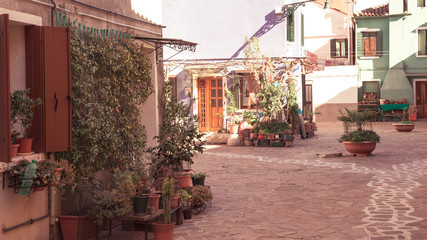 Colorful houses of Burano Island. Venice. Typical street with hanging laundry at facades of colorful houses