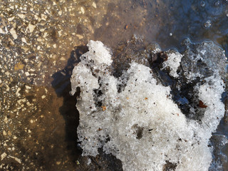Texture of melting snow on the sidewalk closeup in Russia in early spring