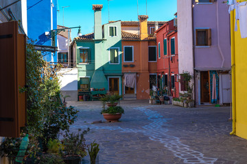 Fototapeta na wymiar Colorful houses of Burano Island. Venice. Typical street with hanging laundry at facades of colorful houses