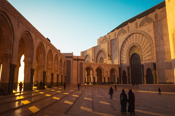 Fototapeta na wymiar people walking in Hassan II mosque's square at sunset - Casablanca, Morocco