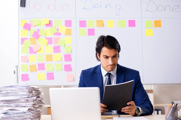 Young handsome employee in front of whiteboard with to-do list
