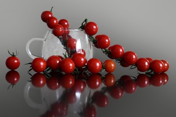 A branch of ripe red cherry tomatoes lying on the table