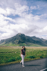 Girl crossing empty road in the mountains