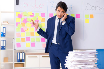 Young handsome employee in front of whiteboard with to-do list