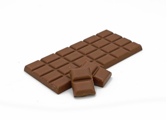 Milk chocolate bar and chocolate pieces isolated on white background