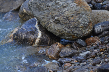 Wet round stones at the mountain river or sea or ocean shore