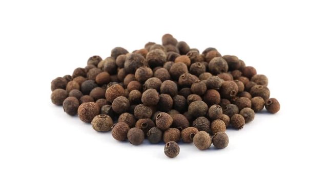 Pile of allspice berries rotating on white background - allspice berries are used as seasoning in the kitchen