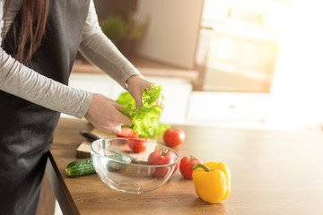 Young trendy woman cooking healthy food in the morning