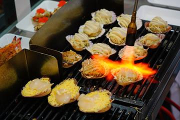 Broiled scallops with cheese on the shell at a fish market in Sydney, Australia