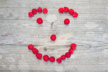 Happy smiling face made of fresh raspberries