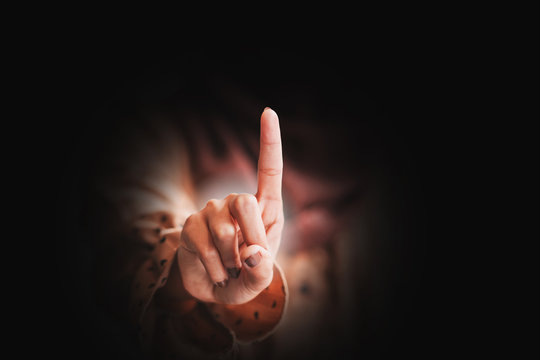 A female hand with the index finger pointing up