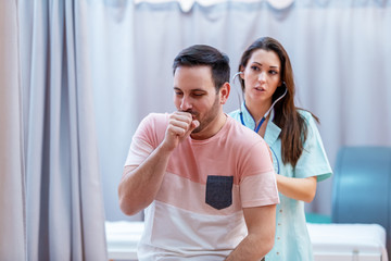 Female doctor examining patient's lungs with stethoscope.