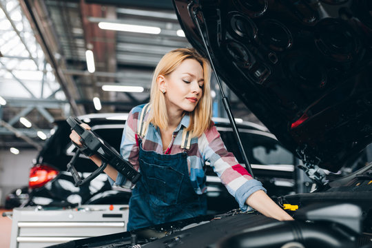 Fair-haired Woman Using Digital Tablet While Diagnosing Car Engine.close Up Photo. Job, Occupation