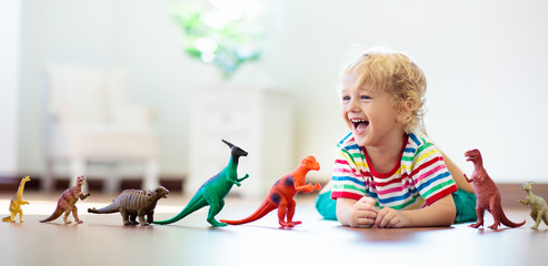 Fototapeta Child playing with toy dinosaurs. Kids toys. obraz