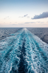 Scenic view of the sea from the stern of a luxurious cruise ship, against the sunrise on a beautiful blue sky