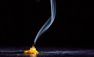 The smoke from an extinguished candle on a black background.