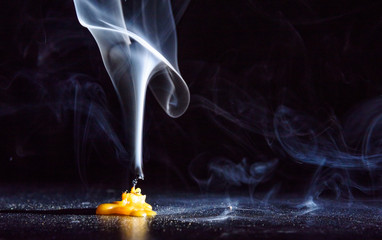 The smoke from an extinguished candle on a black background.
