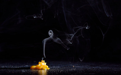 The smoke from an extinguished candle on a black background.