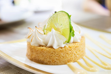 Lemon meringue tart on plate at restaurant.