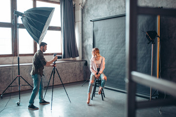 girl in trendy clothes being taken photos for famous magazine, full length photo