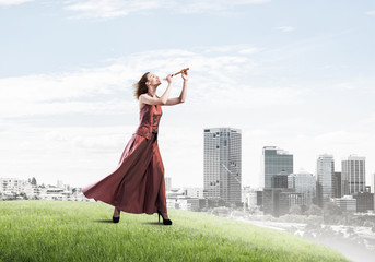 Girl playing her melody on fife at summer bright day