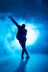 Plakat Full-size of silhouette of male break dancer performing on blue neon stage his expressive dance, Dark blue background with light flare on background