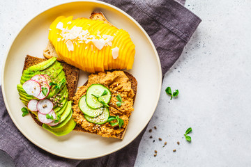 Vegan sandwiches with mango, avocado and tofu pate on a white plate.