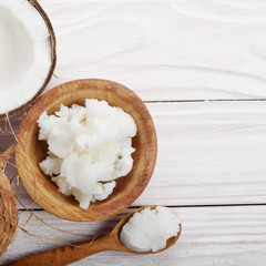 Flat lay background of coconut shell hard oil in wooden bowl on white wooden table