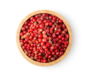 pink peppeer corn in wood bowl on white background. top view