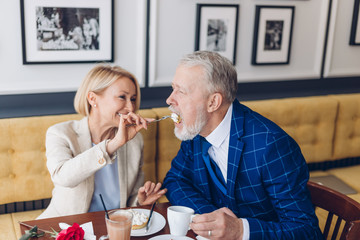 awesome attractive positive woman giving cake to her admirer dessert in coffee shop. close up photo. happiness