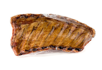 Smoked ribs on a white background. Smoked ribs in a vacuum pack on a white background.