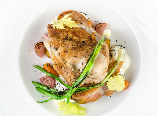Chicken ham with crispy caramel crust and onions on a plate on a white background, top view