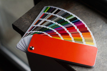 multicolor color paper sampler open on dark marble - obrazy, fototapety, plakaty