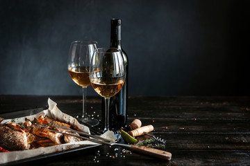 dinner concept for two. two glasses of white wine, baked fish. - 257048185