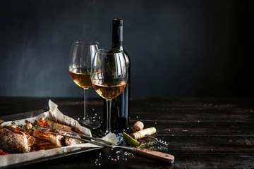 Keuken foto achterwand dinner concept for two. two glasses of white wine, baked fish. © Mikhaylovskiy 