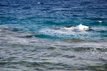 Waves in the ocean. Beautiful blue sea wave photograph close up. Beach vacation at sea or ocean. Background to insert images and text. Tourism, travel.