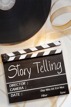 Story telling text title on movie clapper board and 8mm film reel on white background