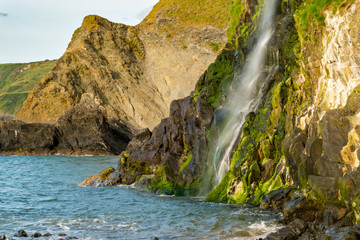 Waterfall of the River Saith cascading into the sea in Tresaith, Ceredigion, Dyfed, Wales, UK