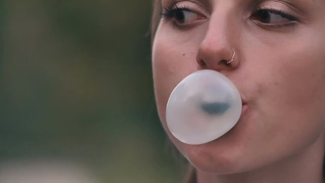 Young girl blowing bubble gum