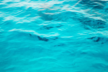 Obraz premium Blue clear water. Beautiful blue sea wave photograph close up. Beach vacation at sea or ocean. Background to insert images and text. Tourism, travel.