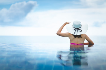Asian woman relax in pool on beach