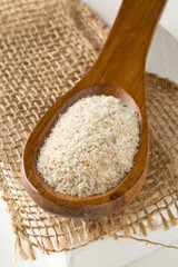 Heap of psyllium husk also called isabgol in wooden spoon on burlap