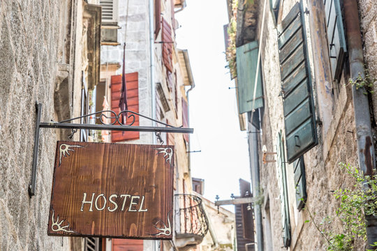 Wooden sign announcing a hostel on a narrow street, Montenegro, Europe - Powered by Adobe