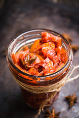 Glass jar with freshly maked orange jam. Selective focus. Shallow depth of field.