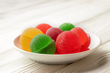 Multicolored spherical jelly candies in a plate