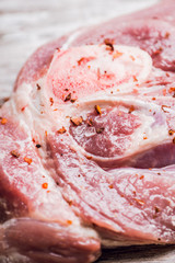 Raw pork meat with salt and spices on the rustic background. Selective focus. 